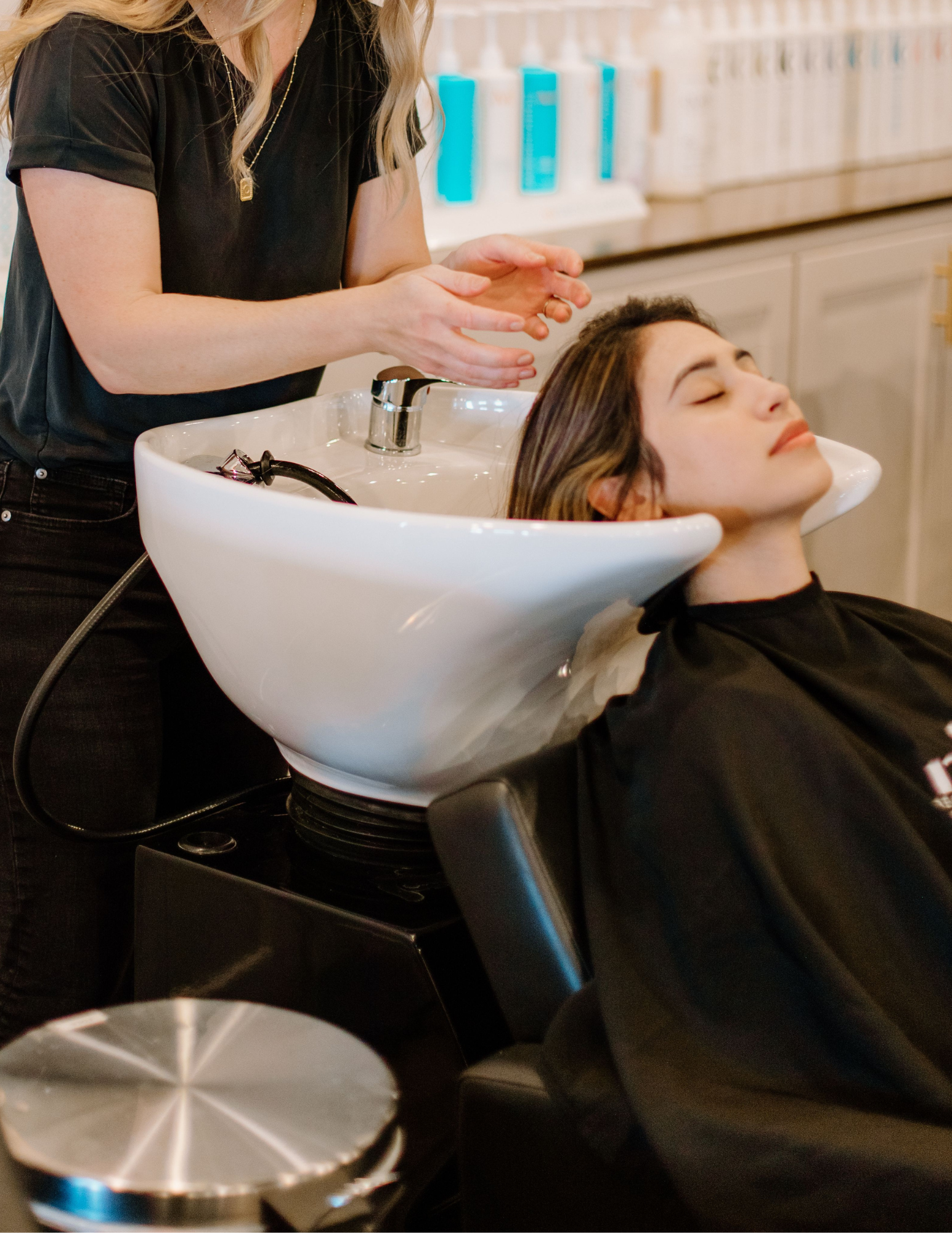 Hair Stylist washing her clients hair at Mosaic Beauty & Boutique